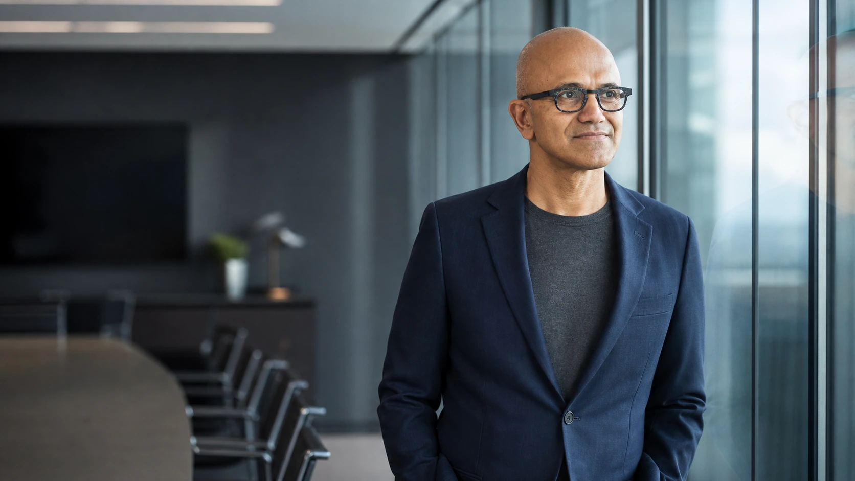 Satya Nadella stojí klidně v moderní zasedací místnosti jako symbol přesného vedení pod tlakem